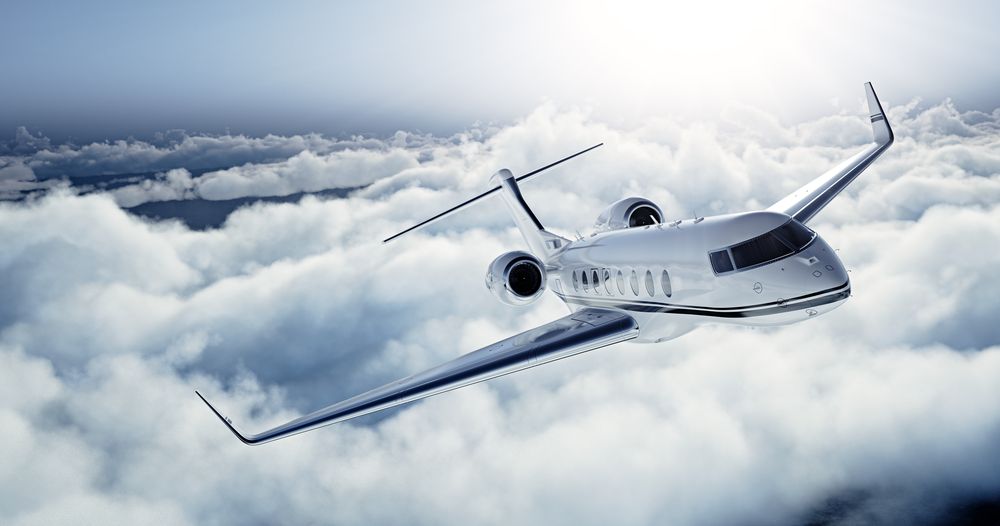 Business jet in flight above the clouds
