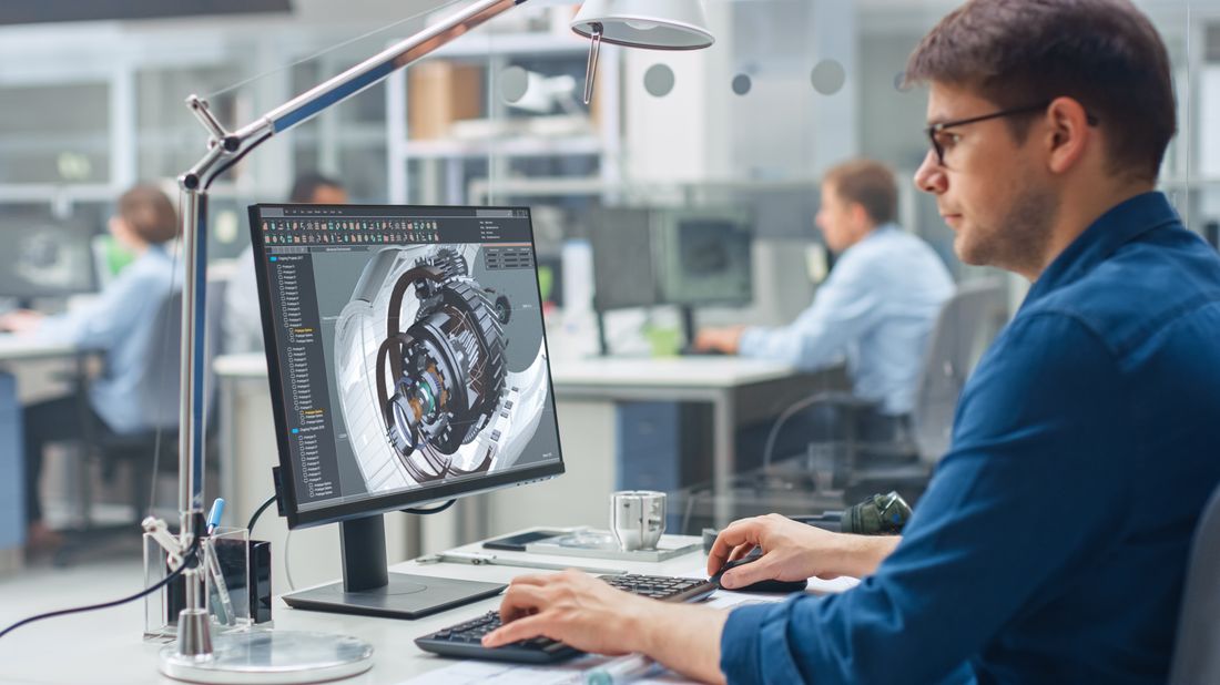 Engineer reviewing a 3D CAD model of a machined assembly