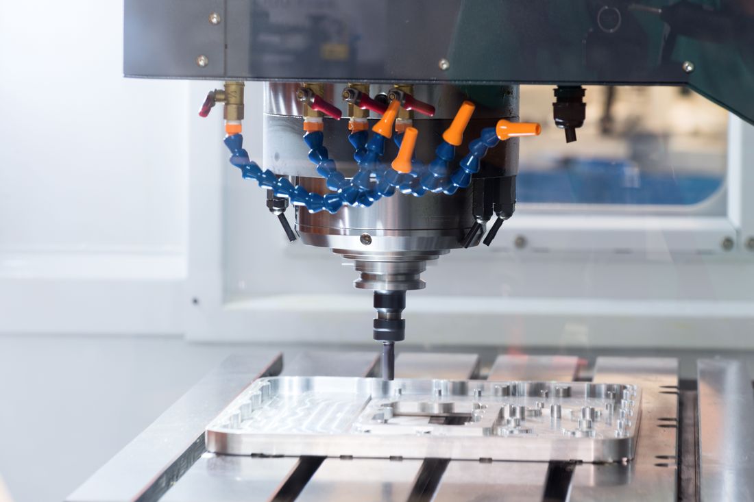 CNC machining center cutting an aluminum aerospace component